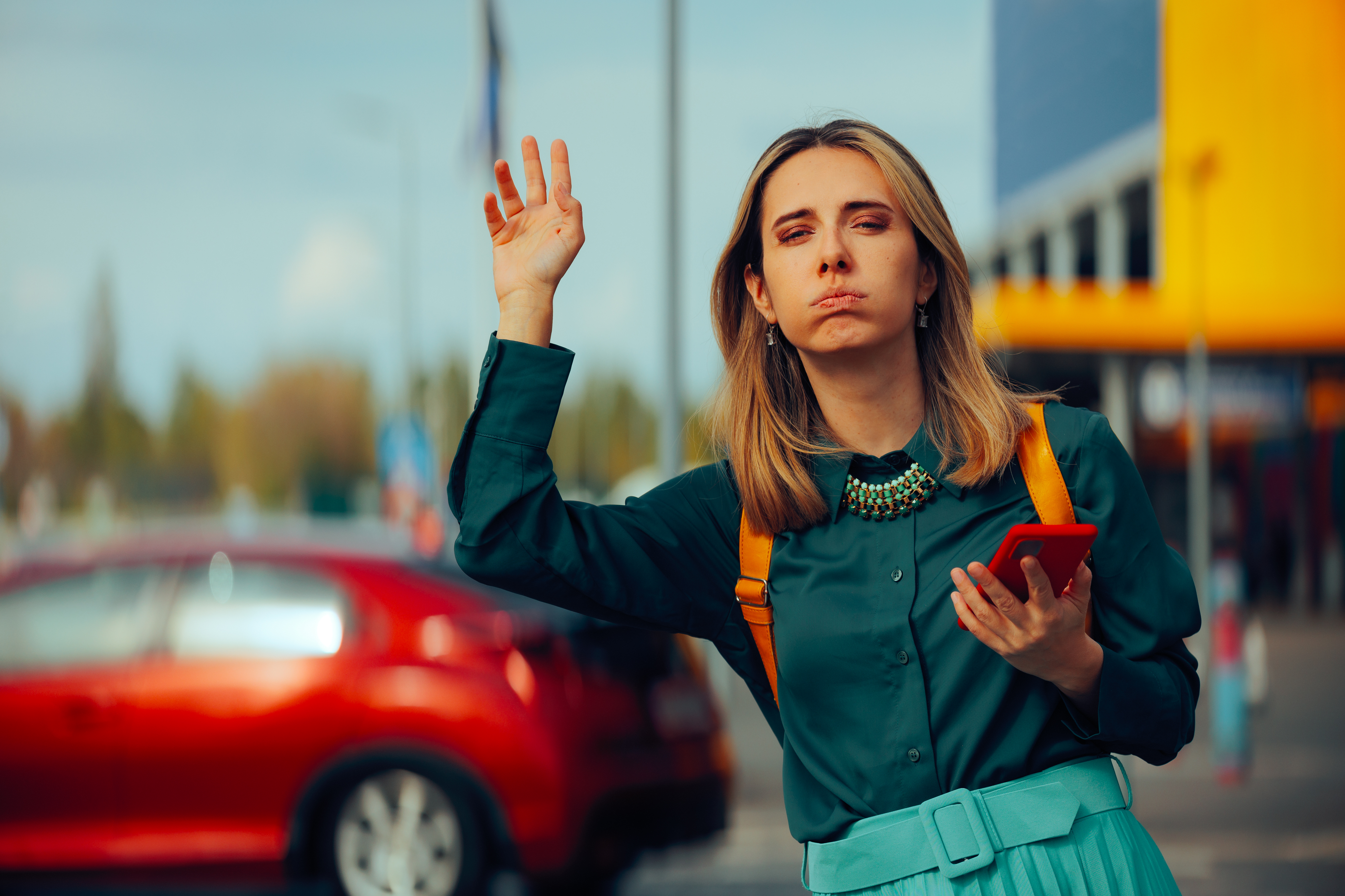 Pasajera solicitando un taxi en la calle desde su teléfono